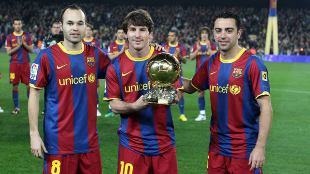 Iniesta y Xavi con el Balón de Oro de Messi