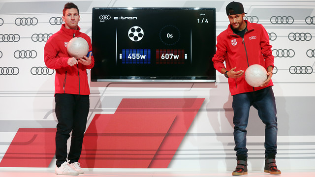 Messi dan Neymar sedang memegang bola dalam acara presentasi Audi